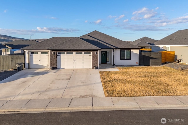 single story home with a shingled roof, fence, driveway, and an attached garage