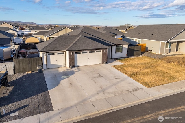 ranch-style home with a garage, a shingled roof, fence, driveway, and a residential view