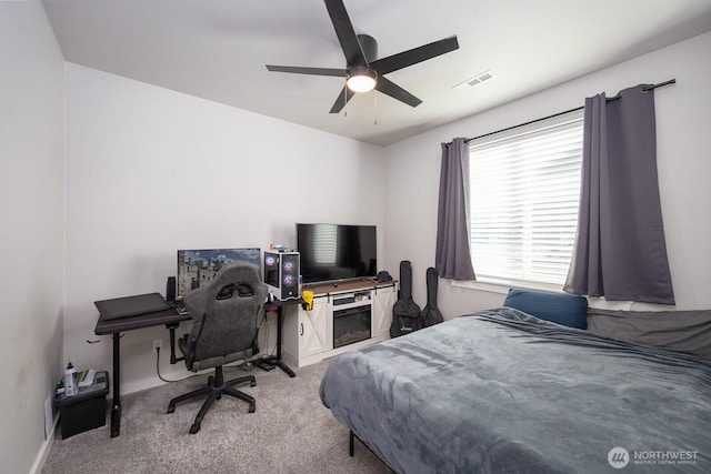 bedroom with visible vents, a ceiling fan, and light colored carpet