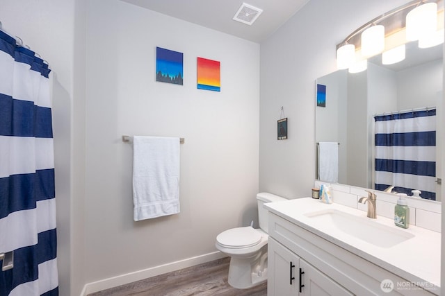 full bathroom featuring baseboards, visible vents, toilet, wood finished floors, and vanity