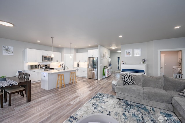 living area with light wood-style floors and recessed lighting