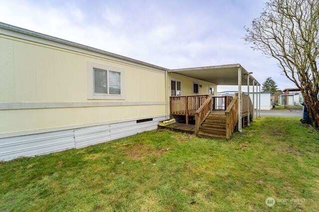 back of house with crawl space, a deck, and a lawn