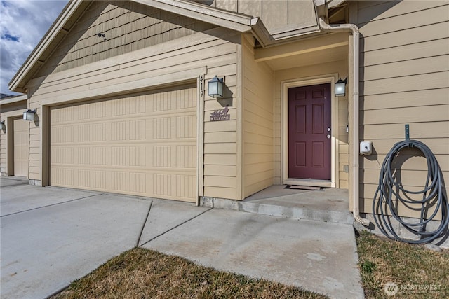 entrance to property with concrete driveway and a garage