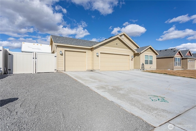 ranch-style home featuring a garage, fence, concrete driveway, and a gate