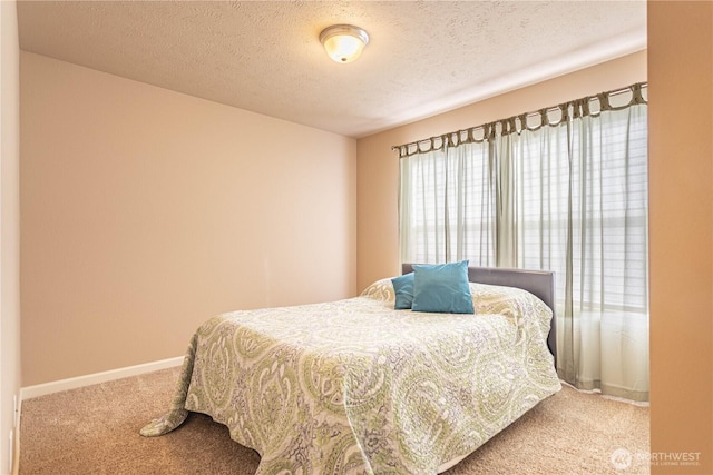 bedroom featuring carpet flooring, baseboards, and a textured ceiling