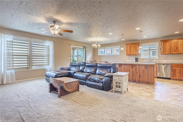 living area with baseboards, light colored carpet, recessed lighting, ceiling fan with notable chandelier, and a textured ceiling