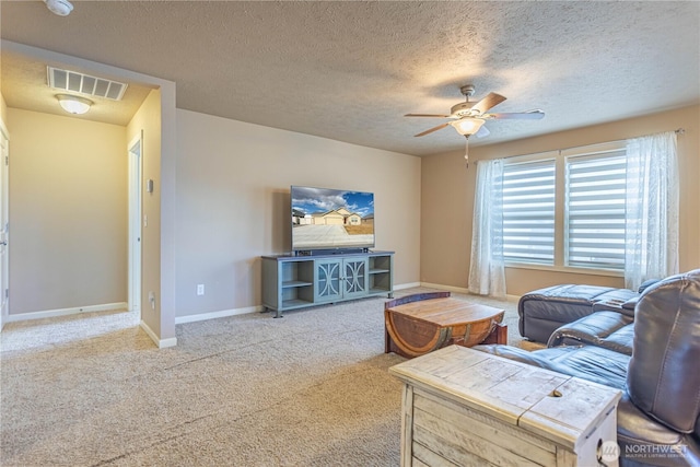 carpeted living room with visible vents, a textured ceiling, baseboards, and a ceiling fan