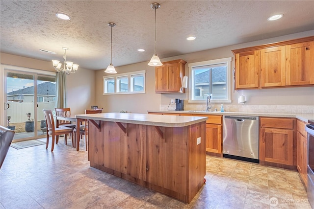 kitchen featuring visible vents, a sink, a center island, light countertops, and dishwasher