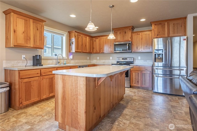 kitchen with a center island, pendant lighting, light countertops, stainless steel appliances, and a sink