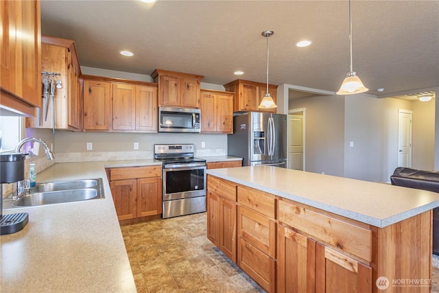 kitchen featuring light countertops, a center island, appliances with stainless steel finishes, and a sink