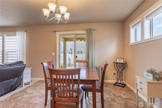 dining area with a notable chandelier and baseboards