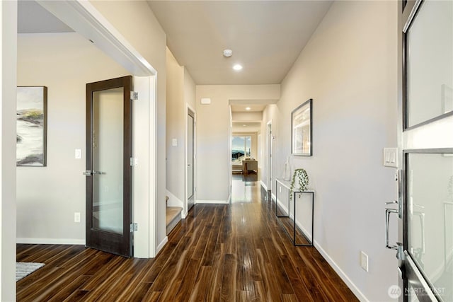 hallway featuring baseboards and wood finished floors