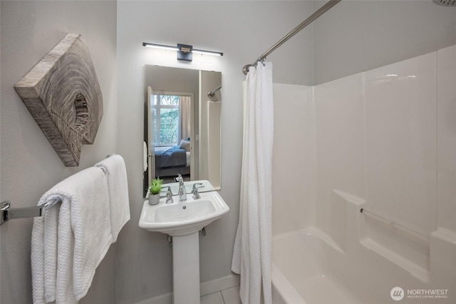 ensuite bathroom with a sink, shower / tub combo with curtain, ensuite bath, and tile patterned floors