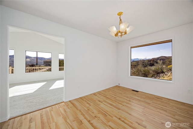133 Long Dr, Chelan, WA 98816 - unfurnished room featuring a notable chandelier, baseboards, a mountain view, visible vents, and wood finished floors