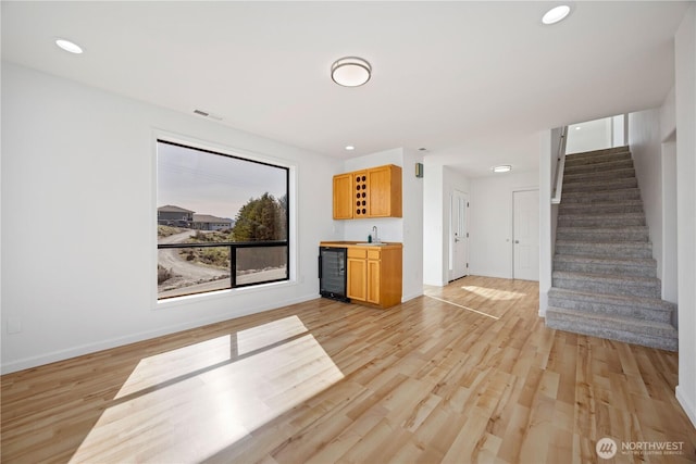 133 Long Dr, Chelan, WA 98816 - unfurnished living room featuring wet bar, stairs, visible vents, beverage cooler, and a sink