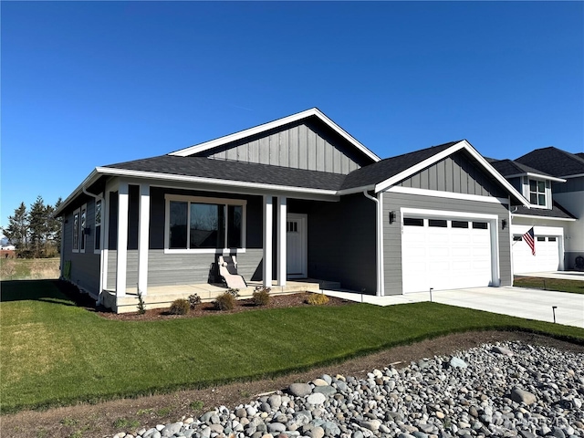 view of front of property with a shingled roof, concrete driveway, an attached garage, a front lawn, and board and batten siding