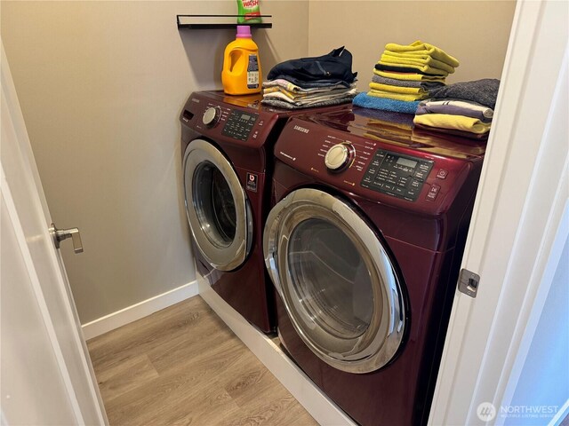 washroom featuring baseboards, laundry area, light wood-style floors, and washer and dryer