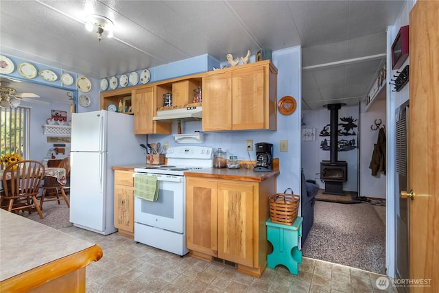 kitchen featuring ceiling fan, under cabinet range hood, white appliances, open shelves, and a wood stove