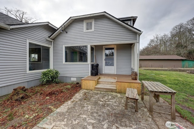 back of house with covered porch, a yard, and crawl space