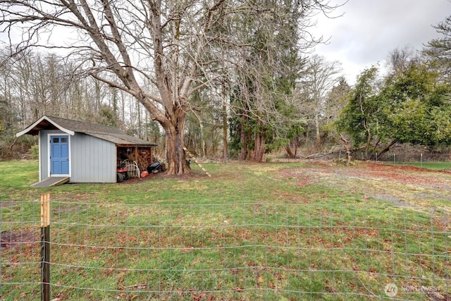 view of yard with an outdoor structure, a storage shed, and fence