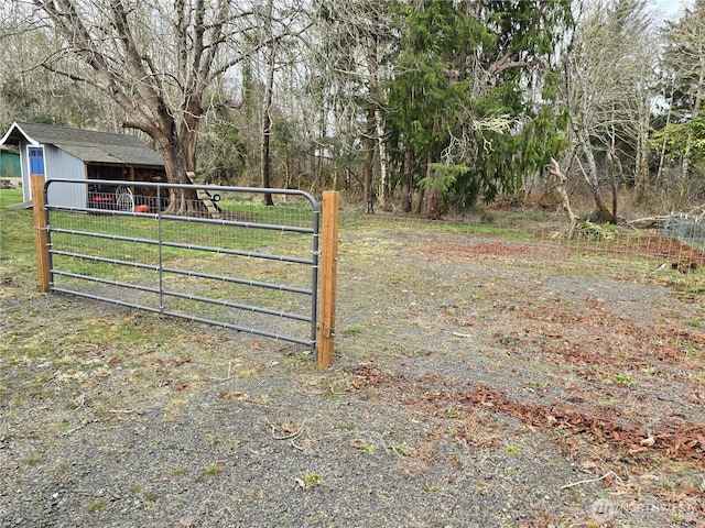 view of gate featuring an outbuilding and fence