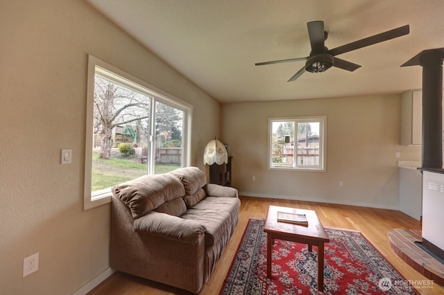 living area featuring light wood-style floors, baseboards, and a wealth of natural light