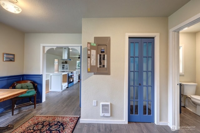 hall with electric panel, a textured ceiling, and wood finished floors