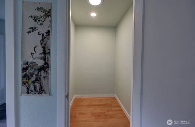 hall featuring light wood-style floors and baseboards