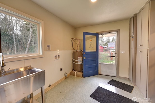 doorway featuring light floors, secured water heater, baseboards, and a sink