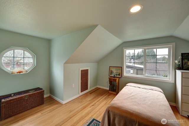 bedroom featuring multiple windows, light wood-style flooring, and baseboards