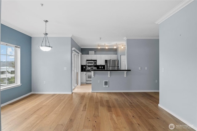 kitchen featuring stainless steel appliances, a peninsula, white cabinetry, light wood-type flooring, and dark countertops