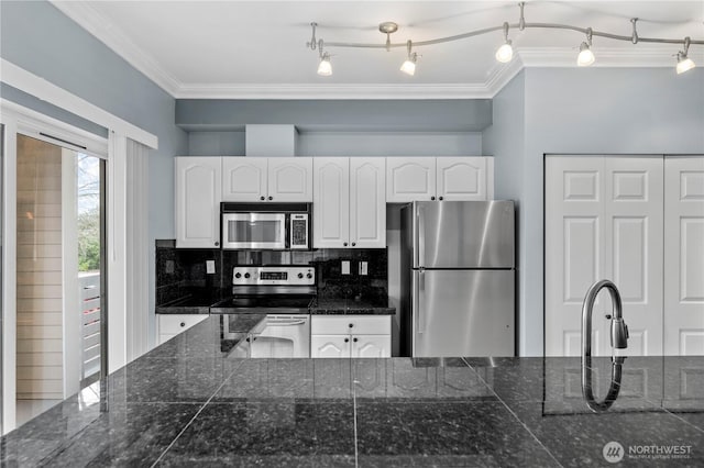 kitchen with white cabinetry, ornamental molding, appliances with stainless steel finishes, tile counters, and tasteful backsplash