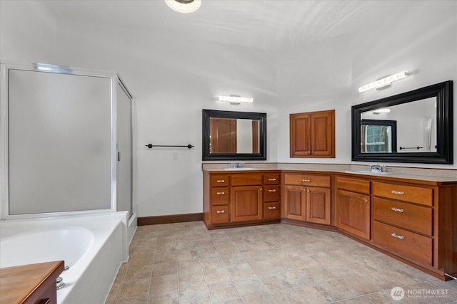 bathroom featuring a stall shower, a garden tub, double vanity, and a sink
