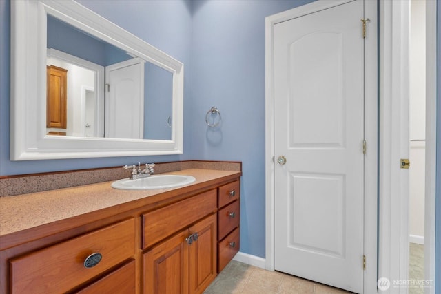 bathroom with baseboards, tile patterned flooring, and vanity