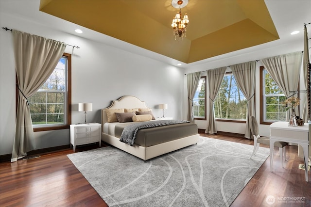 bedroom featuring wood finished floors, baseboards, recessed lighting, and multiple windows