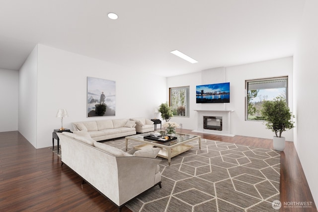living area featuring wood finished floors and a glass covered fireplace