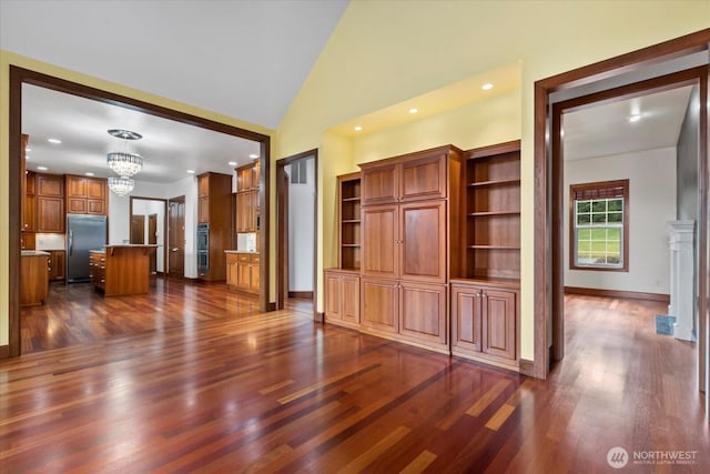 unfurnished living room featuring a notable chandelier, recessed lighting, and dark wood-style flooring