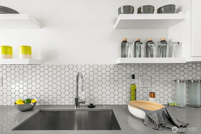 room details featuring open shelves, a sink, and white cabinets