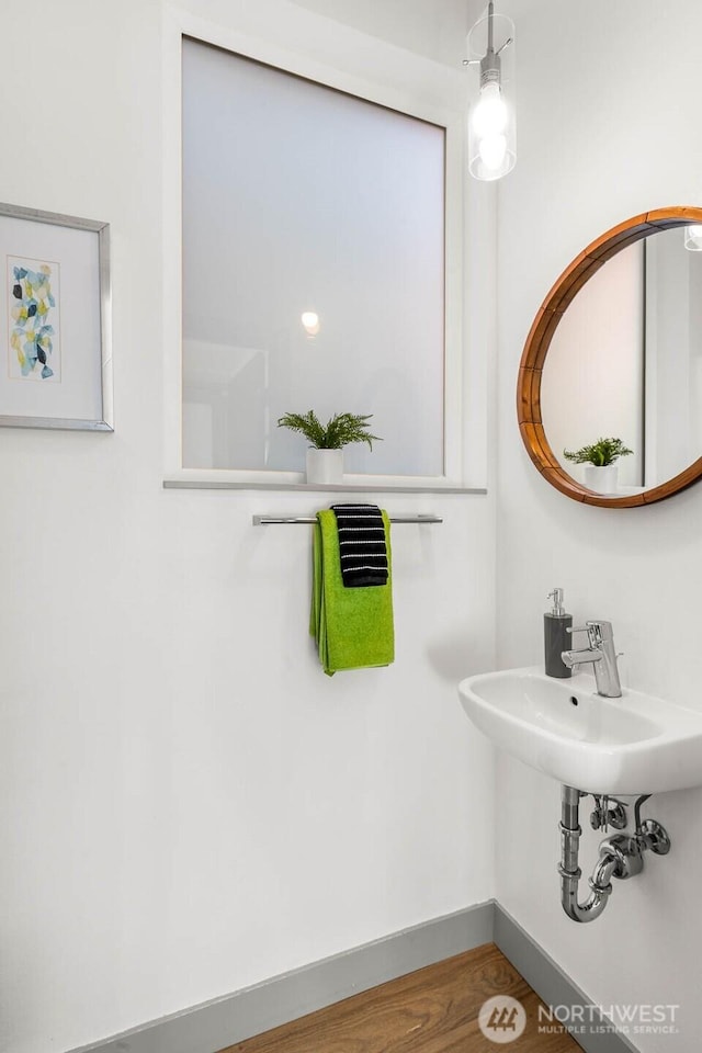 bathroom featuring a sink, wood finished floors, and baseboards