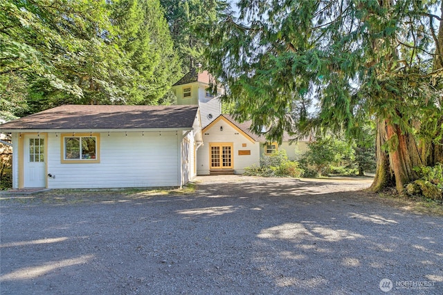 view of front of home with gravel driveway and a chimney