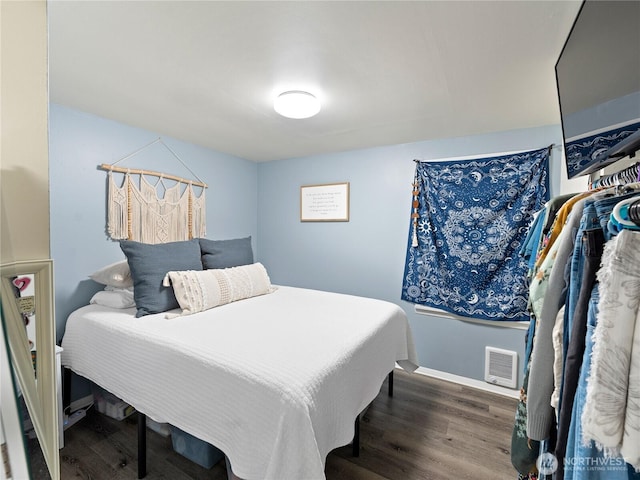 bedroom with visible vents, baseboards, and wood finished floors