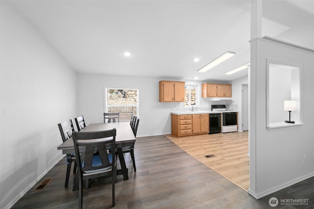 dining space with baseboards, wood finished floors, visible vents, and recessed lighting