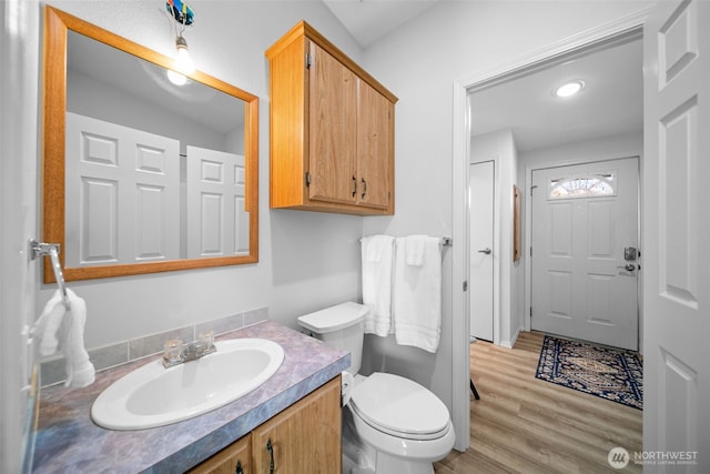 bathroom with vanity, toilet, and wood finished floors