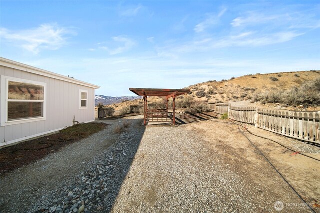 view of yard featuring fence and a mountain view