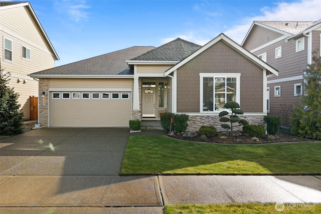 craftsman inspired home with a shingled roof, concrete driveway, an attached garage, a front yard, and stone siding