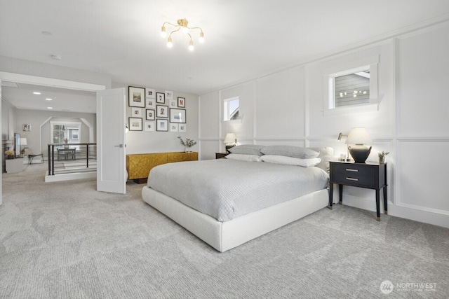 carpeted bedroom with arched walkways and baseboards