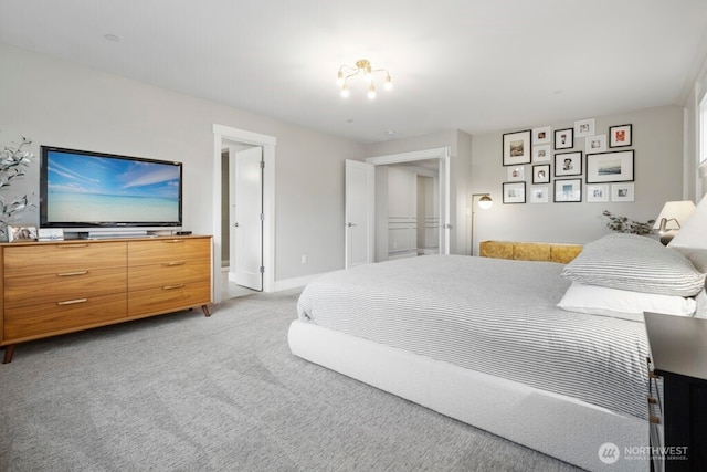 bedroom with light colored carpet and baseboards