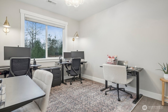 office area with a chandelier, visible vents, baseboards, and wood finished floors