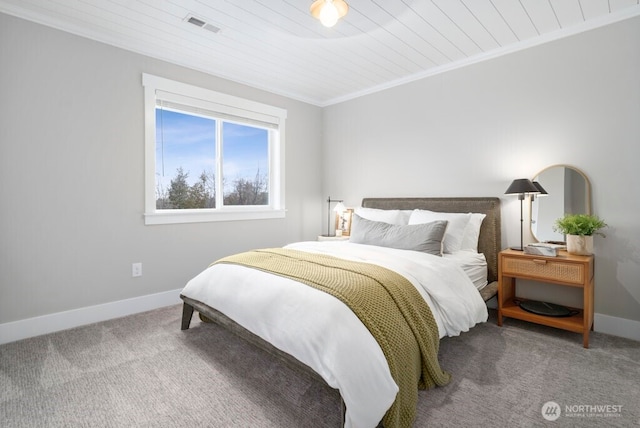 bedroom with crown molding, carpet flooring, visible vents, and baseboards