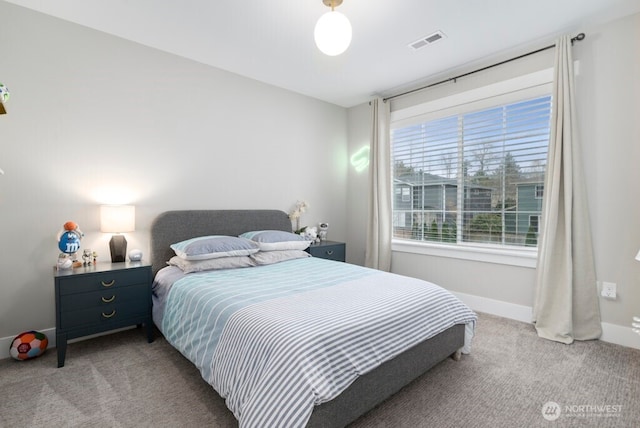 bedroom with baseboards, visible vents, and light colored carpet